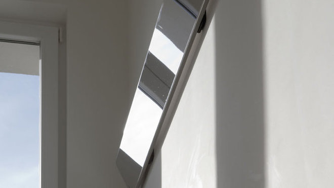 Le réflecteur est ici placé contre le mur à l’horizontale. Il est légèrement décalé du mur avec une inclinaison vers le bas pour faire plonger les rayons du soleil dans la trémie de l’escalier située en contrebas.