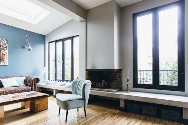 Le salon augmenté de l’extension offre un double volume rythmé par l’ancienne cheminée. Les traces de l’ancienne cloison sont encore visibles.