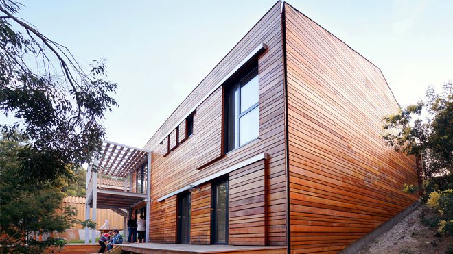 Le Cèdre rouge offre un subtil camaïeu de teintes chaleureuses. Les volets ont été fabriqués dans le même bois, aux teintes dégradées, que les murs extérieurs. On a caché les descentes d’eau pluviales dans une fente de la nouvelle peau boisée.