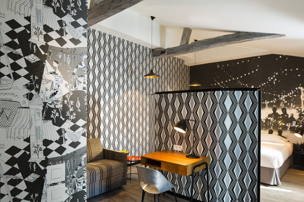 Au cinquième étage, les chambres sont tapissées avec un papier peint illustré de personnages d’époque, qui se coordonne avec un autre motif arlequin et aux rayures des rideaux, déclinées en plusieurs harmonies.