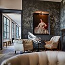 Autour du bar, en toile de fond, le papier-peint crée un espace plus intime, sous l’œil attentif d’un portrait de famille.