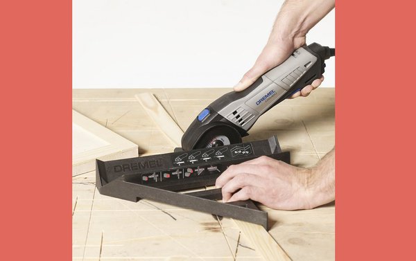 Étape 5: coupez les dix longueurs dans la latte de bois de pin de 36 x 4 mm pour obtenir les détails de portes horizontaux et verticaux, à l'aide de la scie compacte Dremel DSM20 munie d'un disque à tronçonner multi-usage et du guide de découpe Dremel DSM840. Collez et clouez les lattes de bois avec le pistolet à colle Dremel chargé de bâtons de colle pour le bois de 7 mm (GG03) comme vous l'avez fait auparavant, sur les devants de chaque porte ; c'est ce détail qui donnera son style Shaker au meuble.