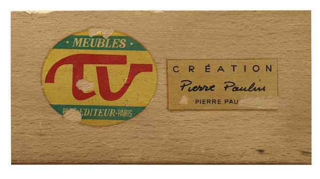 Détail de la banquette 119 avec estampille du créateur et étiquette de l’éditeur.