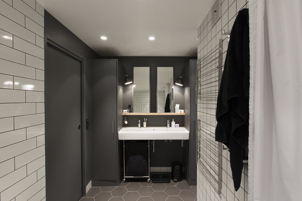 L’alternance du noir et du blanc dessine un rythme dans la salle de bains animée par un jeu de motifs graphiques.