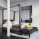 Ambiance dans le showroom parisien de la rue du Bouloi autour du lit à baldaquin Doria réalisé en ébène de Macassar. Dans le fond, le splendide miroir Noor dont le contour de cuir est orné de clous dorés.