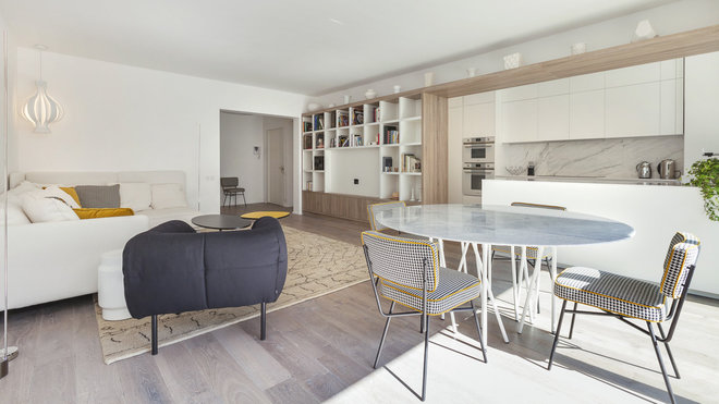 Un grand cadre en noyer américain met en valeur la cuisine. La bibliothèque remplace la cloison existante partiellement abattue pour faciliter la circulation de lumière. Fauteuil Pecorelle, création Cini Boeri chez Arflex. Un grand cadre en noyer américain met en valeur la cuisine. La bibliothèque remplace la cloison existante partiellement abattue pour faciliter la circulation de lumière. Fauteuil Pecorelle, création Cini Boeri chez Arflex.