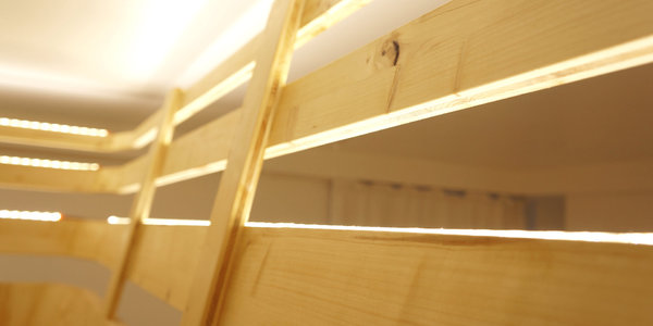 Le lit est protégé par une rambarde en bois.