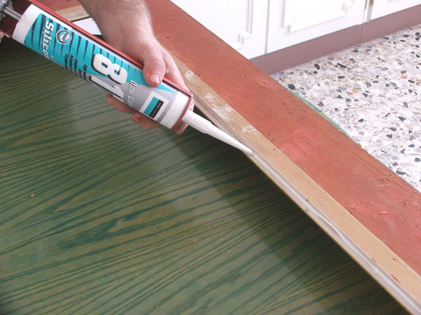 Etape 3 : remplissage du fond de feuillure libéré par un cordon de colle silicone sur le pourtour du cadre.