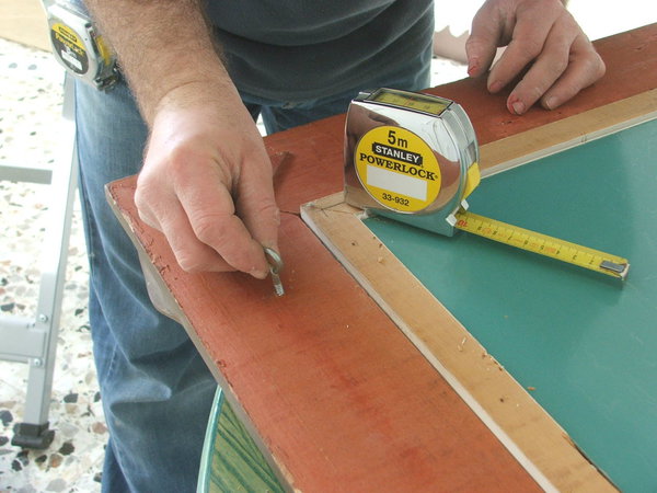 ​Etape 5 : positionnement des crochets d’accroche sur la partie haute du cadre, à gauche comme à droite, au même niveau.