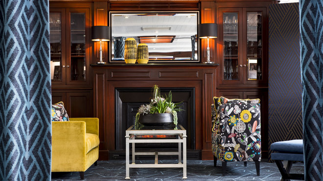Le salon est décoré d'une banquette recouverte du tissu brodé Folie du Jour et d'un canapé de velours mordoré. Tel un écrin feutré, cette pièce est séparée du restaurant ; un paravent recouvert d'un jacquard à losanges bleu nuit et or apporte chaleur et confort.