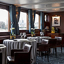 Panneaux acajou, fauteuils en cuir, nappe en lin… Les matières nobles sont au rendez-vous pour un décor sobre et une vue unique sur Paris.