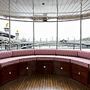 Sur les deux ponts du bateau, de confortables coussins recouverts d’un tissu outdoor composé d’élégants losanges rouges et blancs composent une large banquette.