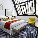 Sous la verrière, côté rue, les lignes graphiques de la structure sont compensées par les couleurs chaudes  et une lumière du jour abondante.