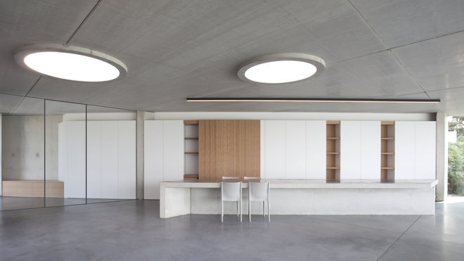 La pièce à vivre est éclairée par deux puits de lumière circulaires.