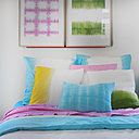 Une chambre à coucher tout en douceur, bleu, jaune, rose et vert utilisés dans différentes techniques de pliage, ou de trempage pour réaliser des toiles à encadrer, des taies d'oreiller, une couette et le drap qui va avec.
