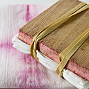 une serviette pliée et maintenue avec 2 planches de bois et des élastiques.