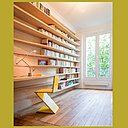 Le coin travail du bureau est intégré dans un linéaire d’étagères de 5 mètres de longueur à la profondeur variable qui joue avec les nez de murs de largeurs différentes (30 cm d’un côté et 40 cm de l’autre).  L’effet en courbe adoucit l’ensemble et contraste avec les formes rectilignes de la chaise Zig Zag de Gerrit Thomas Rietveld, toujours éditée chez Cassina.