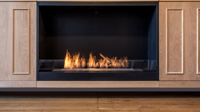 La cheminée au bioéthanol (Ignisial) offre une alternative moderne au feu traditionnel et s’intègre sans danger dans le rangement du salon.