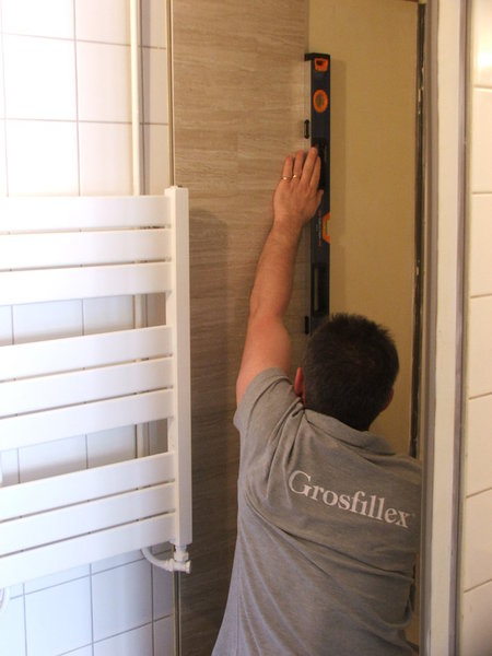 Etape 9 : pose de la première lame. Plaquez la lame de revêtement contre le mur et contrôlez le niveau.