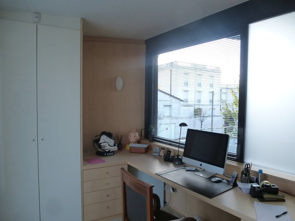 Le bureau a été optimisé avec un plan de travail intégré dans un système de rangement complet et optimisé.