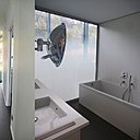 Immaculée, hormis son sol, comme les espaces de circulation, la salle de bains joue la carte de noir et blanc.