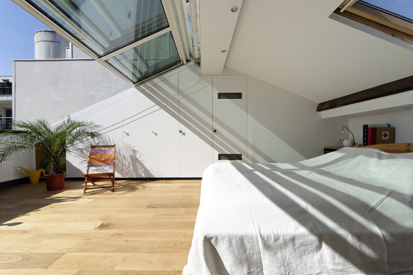 Un grand placard a été aménagé dans la pente du toit. La première porte toute hauteur permet de communiquer avec les chambres des filles, tandis que la porte munie d’une grille haute et basse cache un appareil de ventilation intégré. Les trois panneaux de la verrière coulissante se replient sur un quatrième fixe panneau fixe.