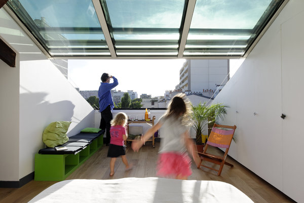 La chambre parentale offre une vue sur les toits de Paris et un espace détente et jeu pour toute la famille.