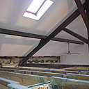 Avant travaux : lors des travaux, la dalle haute a été démolie et abaissée de 40 centimètres pour augmenter la hauteur sous combles trop faible. Des profils métalliques de 7 mètres de long ont été mis en place pour renforcer les façades et assumer la descente de charge. Il a fallu couper la traverse inférieure de la charpente pour ne pas gêner le bon déroulement des travaux.