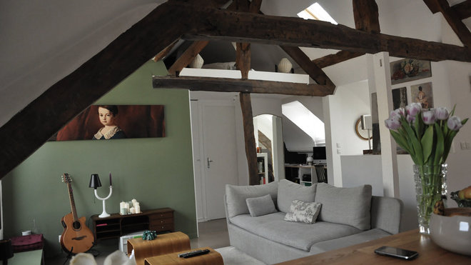 Toutes les poutres de la charpente ont été conservées. La chambre des parents visible du salon est accessible du bureau, grâce à un escalier discret.