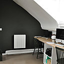 Derrière le dressing ouvert sur le coin bureau, un escalier peint en noir s’intègre à l’espace et permet d’accéder à la chambre aménagée sous le faîtage du toit.