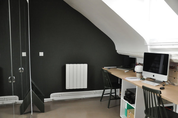 Derrière le dressing ouvert sur le coin bureau, un escalier peint en noir s’intègre à l’espace et permet d’accéder à la chambre aménagée sous le faîtage du toit.