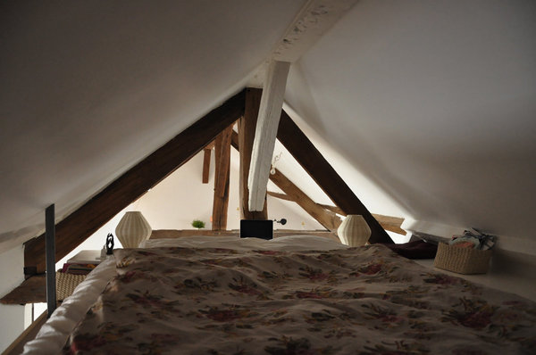 La chambre des parents est matérialisée par un lit qui occupe tout l’espace de la mezzanine.