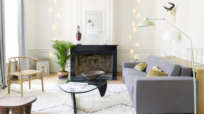 Au premier étage, un salon tout blanc met en valeur, les lignes classiques des boiseries et les pièces graphiques du mobilier. Table basse signée Isamu Noguchi,  chez Vitra, chaise Wishbone CH24 de Hans Wegner, The Conran Shop.