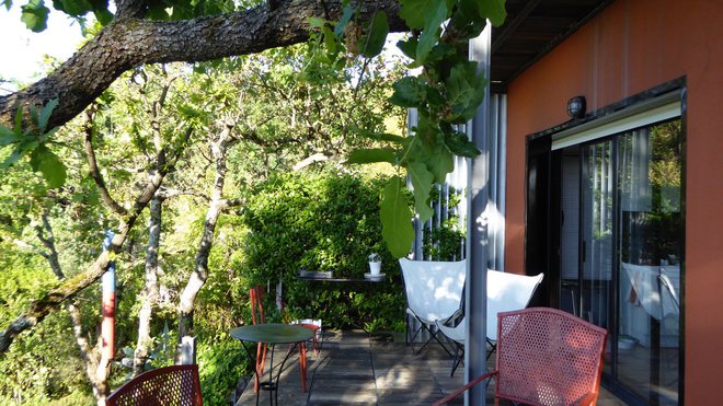 La maison profite d’une terrasse ombragée en bois exotique.