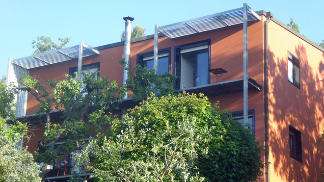 La maison sur trois niveaux s’élève dans un vaste jardin de 1 800 m² planté d’essences locales et rythmé de murs de retenue en pierre sèche.