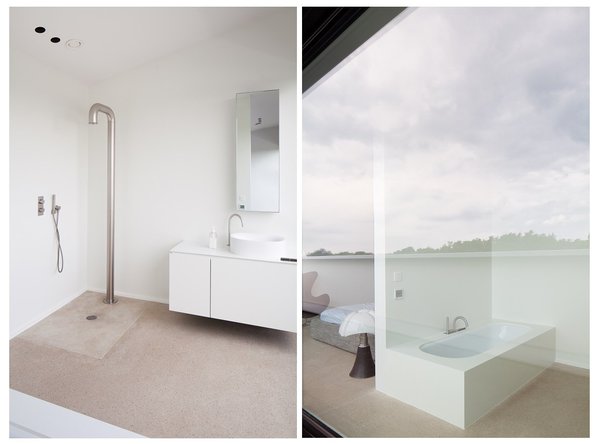 La salle de bains minimaliste offre un bac à douche à fleur de sol et une baignoire avec vue sur l’extérieur.