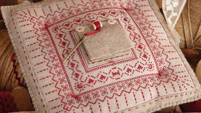 Le coussin surprise en lin clair brodé de feutrine beige.