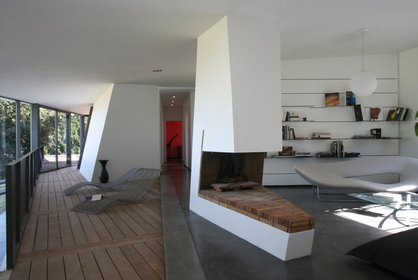 La cheminée joue avec la géométrie de l’espace, dessinant un coin bibliothèque ouvert.