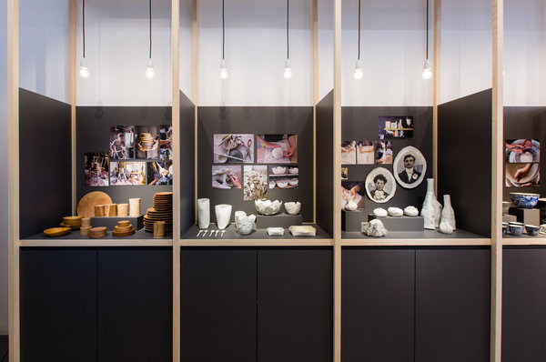 Les objets d’art de la table sont présentés dans des alcôves aux tons foncés qui contrastent avec les matières.