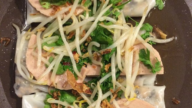 Les rondelles de  mortadelle vietnamienne sont disposées sur les Banh Cuôn, décorez de coriandre et de germes de haricots mungo.