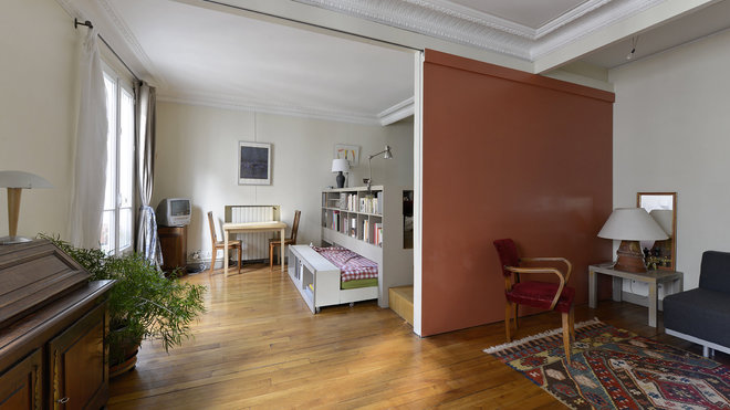 Le lit est dissimulé sous l’estrade. Au niveau du sol, il suffit de tirer le dernier rayonnage de façade de la bibliothèque pour le faire apparaître. Il s’agit d’un couchage classique de 160 cm. Le matelas et le sommier sont installés sur un châssis à roulettes en MDF.