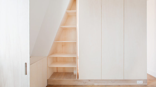 Côté pile, dans la chambre, la tête de lit fait office de séparation de pièce et le mur en soupente a été exploité en bibliothèque. Dans la tête de lit, des rainures, toute hauteur, ont été dessinées pour lui donner l’aspect d’une armoire, en trompe-l’œil.