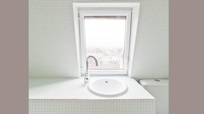 Installé sous la pente et la fenêtre de toit, le plan vasque n’encombre pas l’espace au sol. A sa gauche, il dégage une plage de rangement pour disposer tous les accessoires de toilette.