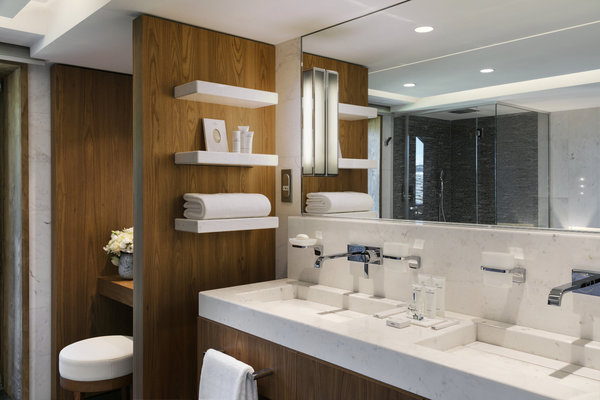 La salle de bains est conforme aux prestations de l’hôtellerie de luxe, avec ses larges vasques et le soin apporté aux détails.