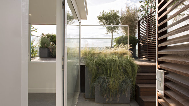 Les terrasses séparées par des claustras en bois pour conserver l’intimité et rythmées par des différences de niveaux dessinent un espace à vivre en continuité des espaces intérieurs.