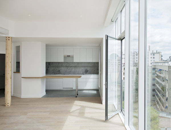 Une table qui s’insère dans un pan de mur ouvert fait office de séparation de pièce.