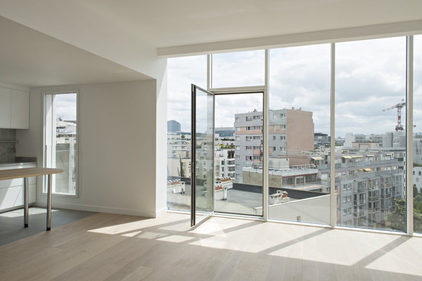 Une large baie vitrée éclaire le niveau inférieur, baigné de lumière.