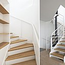 L’escalier intérieur avec ses dessus de marches en bois est intégré à une bibliothèque au second niveau.