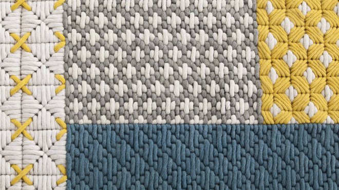 Gros plan sur le tapis de la collection Silaï qui compose une base pour poser des tables, des poufs et des coussins.