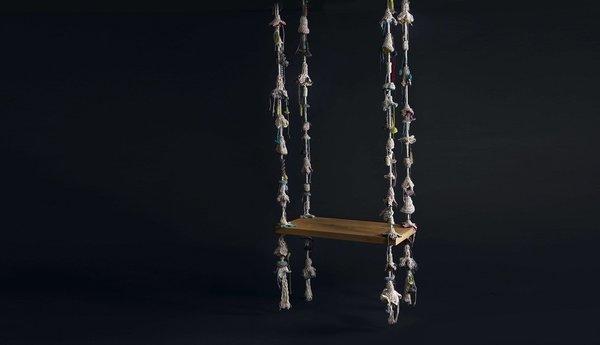 Balançoire d’intérieur avec cordes décoratives imitant des lianes végétales et fleuries.